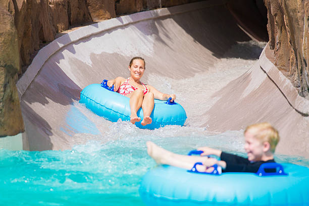 istock Family enjoying a wet ride down a water slide 477338218