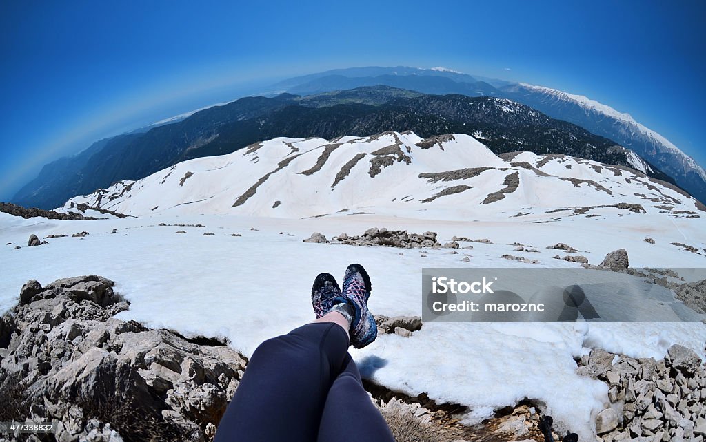 Legs of traveler sitting on high mountain top in Turkey Girl hiking .Snow on the top of the Tahtali mountain in Turkey The Bigger Picture Stock Photo