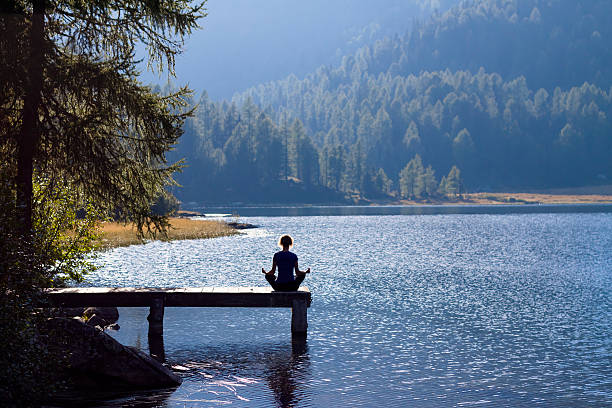istock Woman doing yoga at lake 477338872