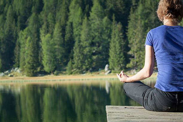 istock Woman doing yoga at lake 477338894
