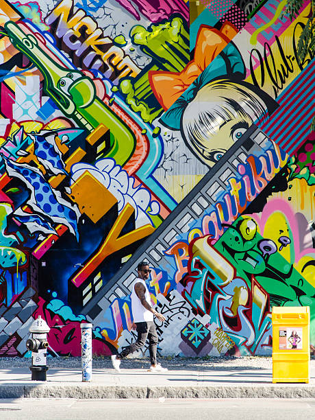 hipster hombre caminar junto a la pared de graffiti en brooklyn - graffiti paintings men walking fotografías e imágenes de stock