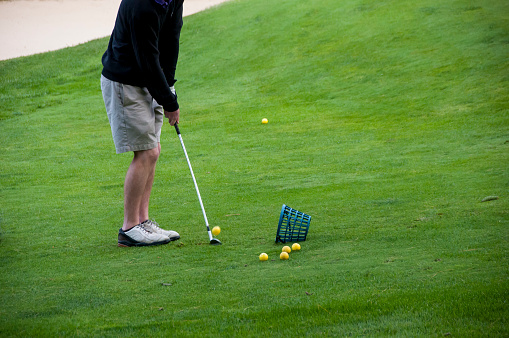 Small golf tournament, golfers marking their ball position before their turn for putting