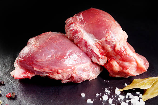 Fresh and raw meat. Cheeks, red pork  grill or barbecue. Fresh and raw meat. Cheeks, red pork ready to cook on the grill or barbecue. Black slate background cheek stock pictures, royalty-free photos & images