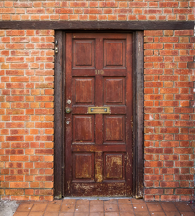 Entrance door to the old building located in the brick wall.