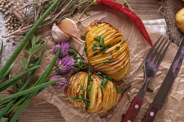 istock Sliced baked potatoes over wooden background. 477349486
