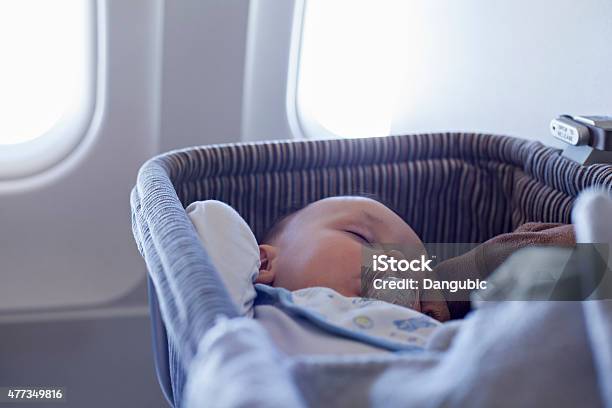 Baby Boy Sleeping In Bassinet On Airplane Stock Photo - Download Image Now - Baby - Human Age, Airplane, Crib