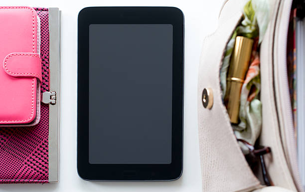 istock woman's wallet and phone next to a tablet and purse 477356994