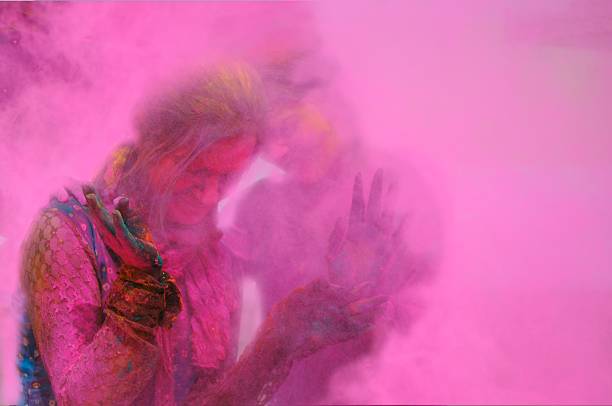 Two females standing in the fog of colors/ gulal during Holi celebration in India.