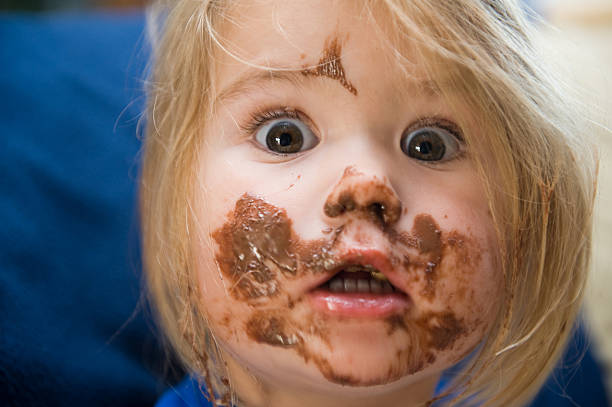 Girl is eating girl is eating, girl, eat, chocolate, meal, horizontal candy in mouth stock pictures, royalty-free photos & images