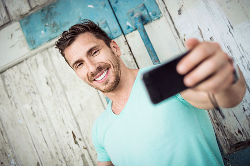 Handsome man taking selfie and posing