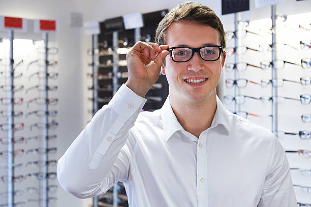 istock Man Choosing New Glasses At Opticians 477372764
