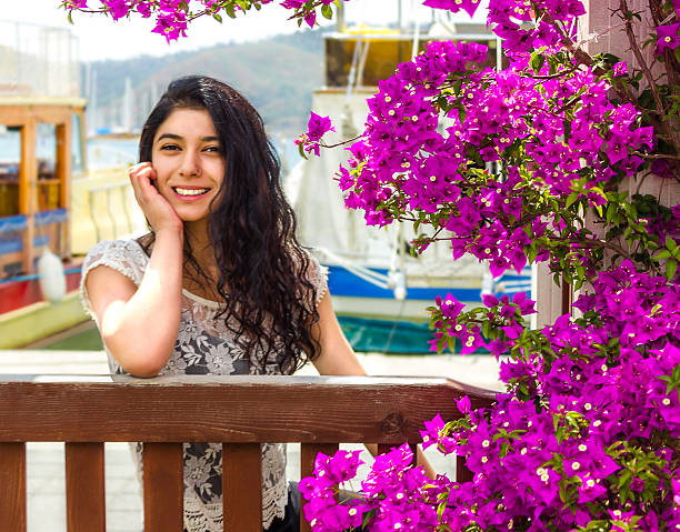 Smiling woman in bougainvillea flowers  and resort town stock photo