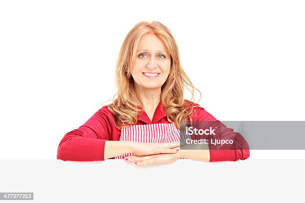 Mulher Madura Vestindo Um Avental E Posando Em Branco Do Painel - Fotografias de stock e mais imagens de 40-49 Anos