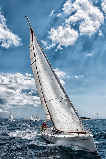 Front view of white sailboat during regatta, manipulated colors
