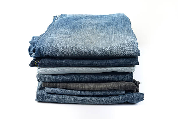 istock Stacked Blue and Black Jeans on White Background 477380994
