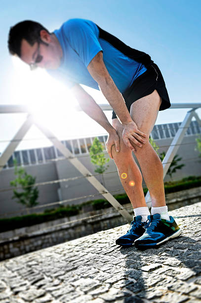 istock man exhausted after running taking a rest breathing to recover 477381146