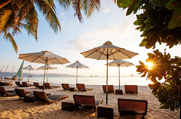 istock Sun umbrellas and beach chairs on tropical beach 477385418