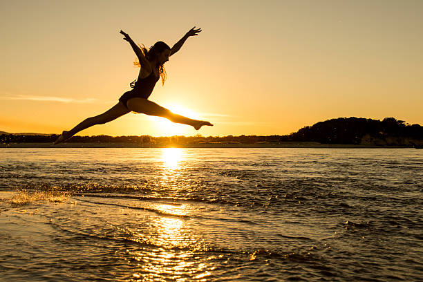 Girl jumping across water