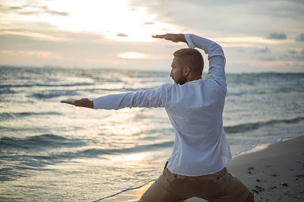 giovane uomo esercizio di yoga, thai chi - sunset yoga young men caucasian foto e immagini stock