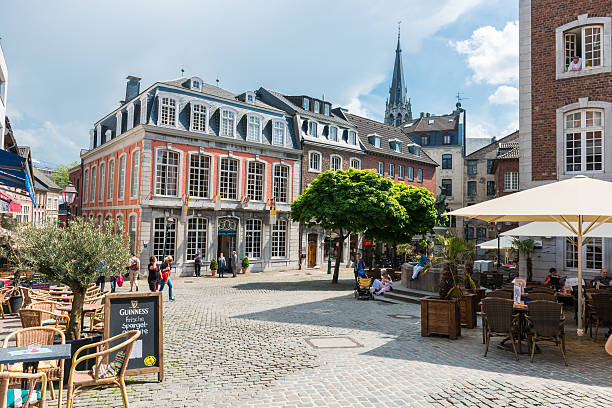 Aachen, Germany - May 20, 2012: Historic city centre of very old town Aachen in Germany. Lot of pubs with many people in very narrow alleys. Most of buildings have brickwalls  and most streets have cobblestones.
