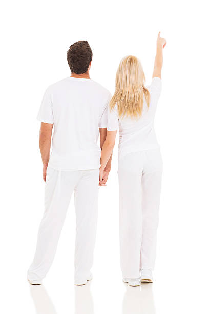 rear view of couple pointing up isolated on white background