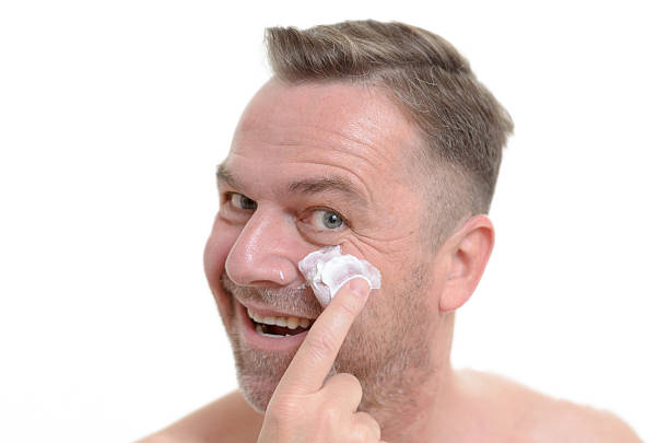 istock Man applying moisturizer to his skin 477390554