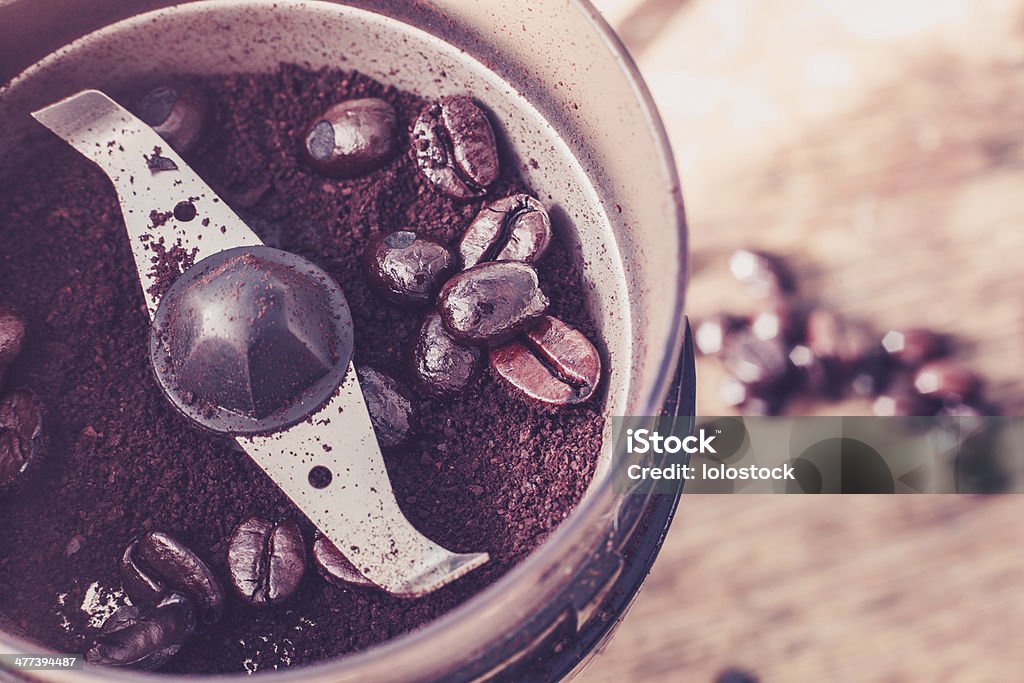 Electric coffee grinder Close up on an electric coffee grinder with beans Grinding Stock Photo
