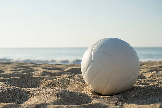 White volleyball on sand beach, sea at background, beach volleyball