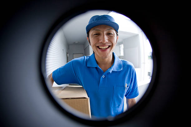 Delivery person seen through peep window stock photo