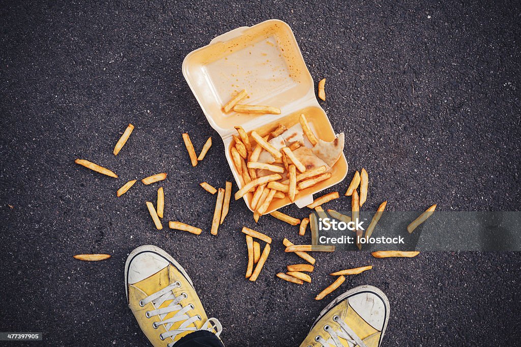 Man dropping his chips Young man has dropped his chips in the street Falling Stock Photo