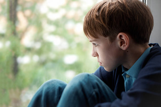 istock Sad teenager sitting on window 477399899