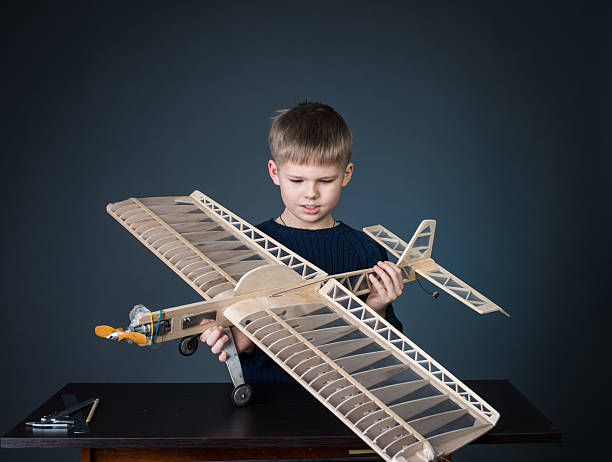The child making a plane. He used cardboard and paper. This is an innovation for his. He is a successful student at the age of 4-5.