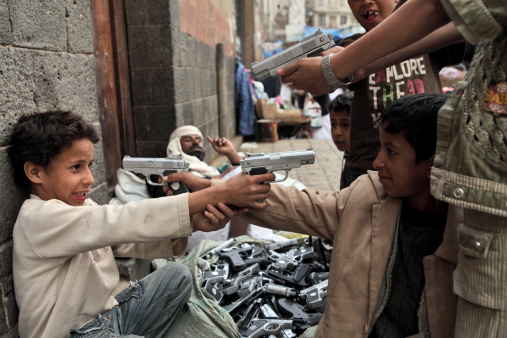 Sanaa, Yemen - March 22, 2012: Children playing with toy guns on the street of Sanaa