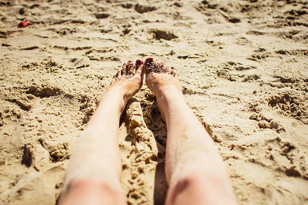 istock young woman legs sunbathing on the beach 477400634
