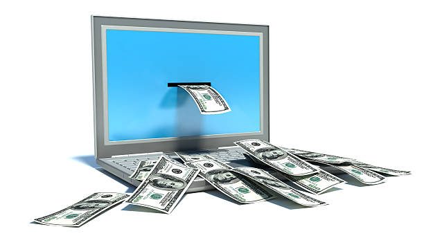 istock making money online - withdrawing dollars from laptop 477405973