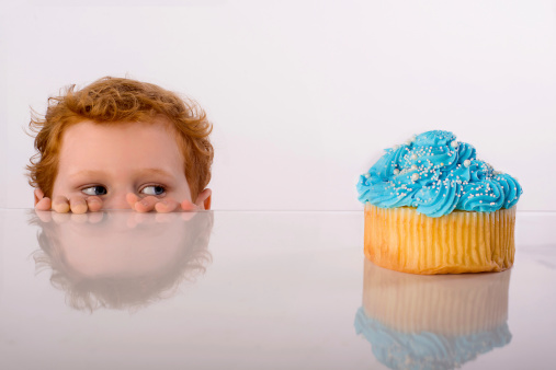 A young man eyes a delicious cupcake