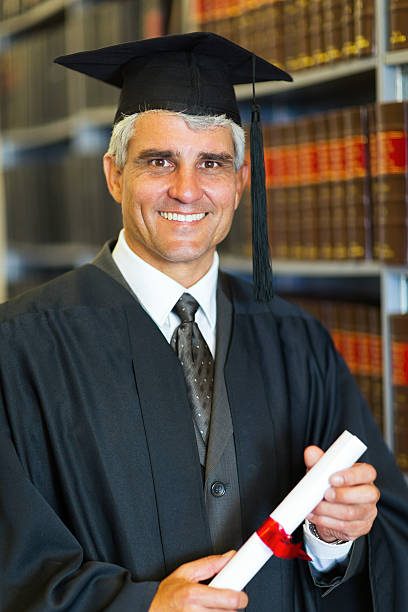 istock mid age male graduate holding diploma 477414053