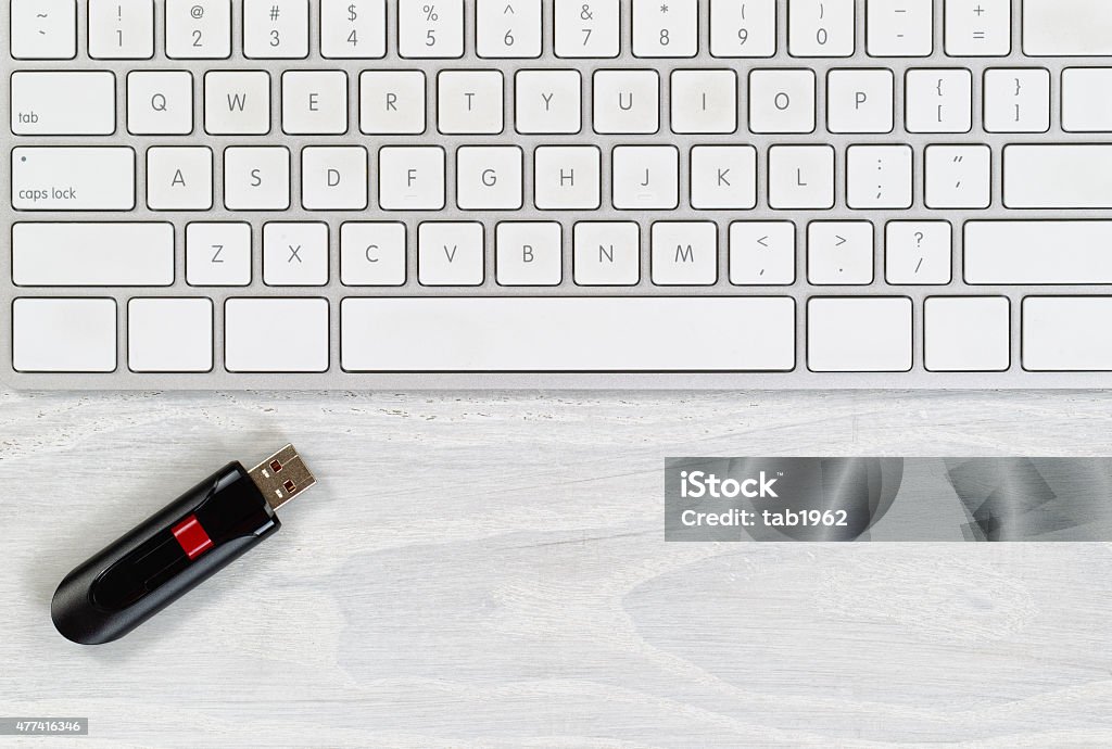 Desktop with keyboard and data thumb drive White office desktop with computer keyboard and thumb drive. Top view with plenty of copy space. 2015 Stock Photo