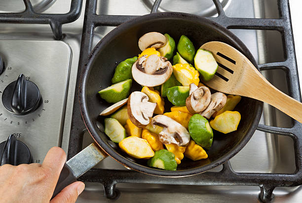 istock Stirring vegetables in Frying Pan with wooden spoon 477416764