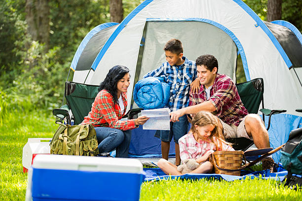 Family camping outdoors in forest. Tent, supplies. Summer vacation. stock photo