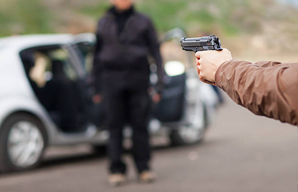 l'approche de la voiture avec une arme à feu - gun handgun violence kidnapping photos et images de collection