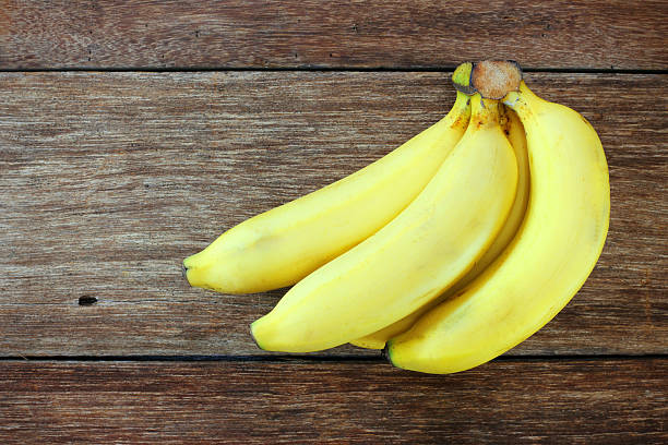 istock Fresh bananas on wooden background 477419306