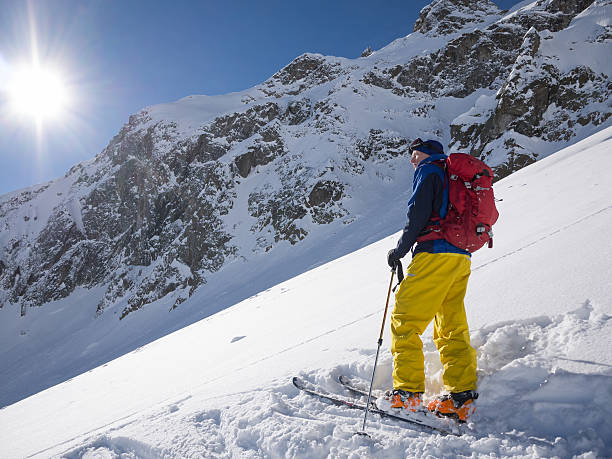 istock Skier looking out over slope with powder snow 477422885
