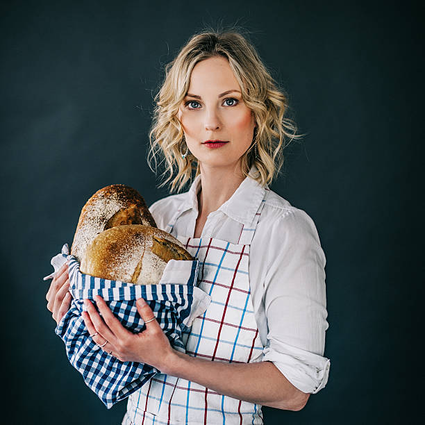 istock Young woman holding freshly made bread 477423380