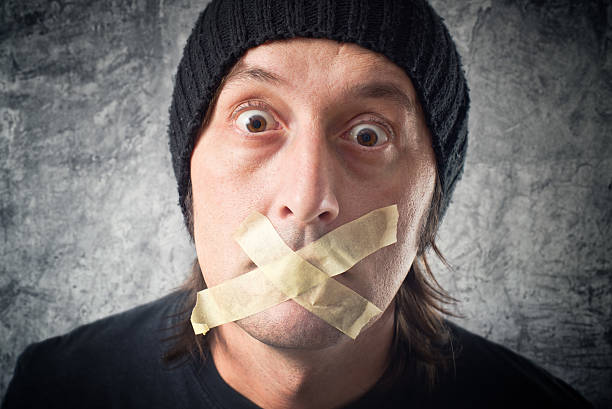 istock My lips are sealed. Man with tape over his mouth. 477423491