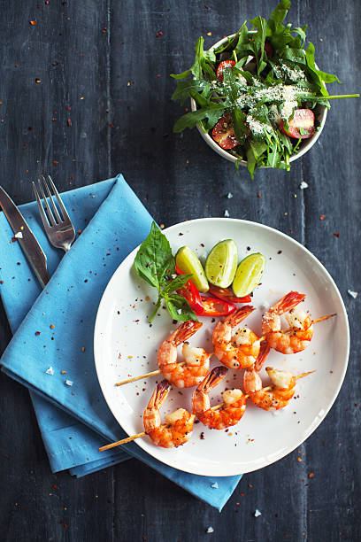 Grilled shrimps Grilled shrimps on skews with lime slices and salad black tiger shrimp stock pictures, royalty-free photos & images