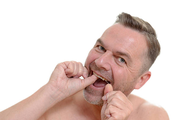 istock Man flossing his teeth with dental floss 477424916