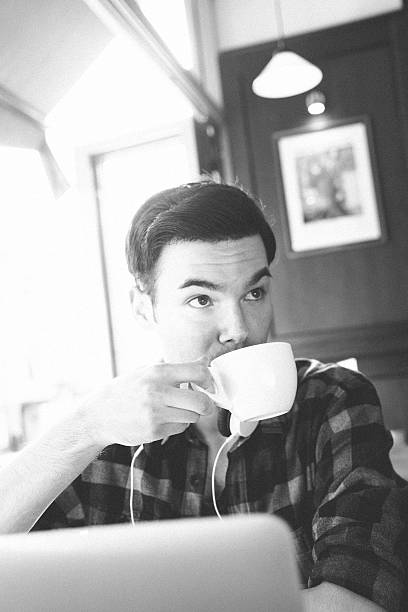 istock Cheerful Young Man Using Laptop In Coffee Shop 477427750