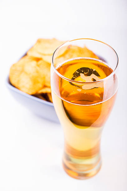 Glass of beer and chips isolated on white background