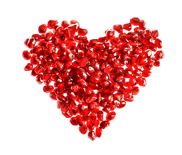 istock Red heart shape made of pomegranate seeds on white background. 477430143